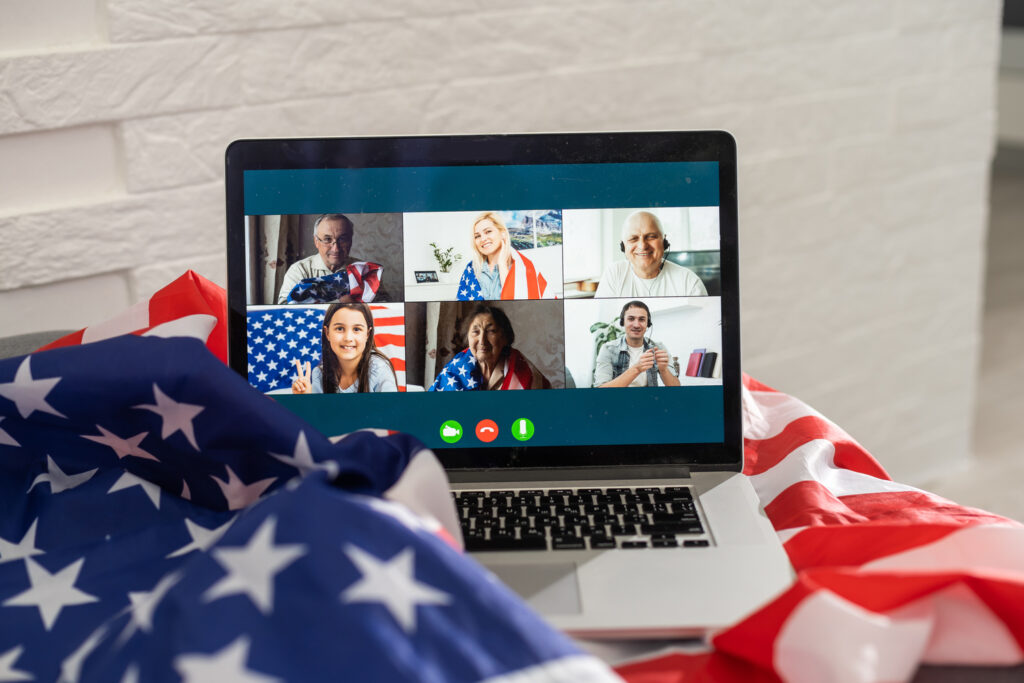 Aluno participando de aula de inglês online ao vivo por videoconferência, interagindo com professor em tempo real