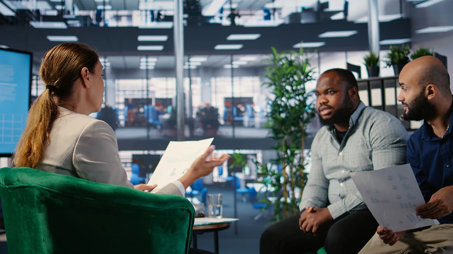 Profissional recebendo feedback construtivo em inglês em ambiente corporativo multicultural